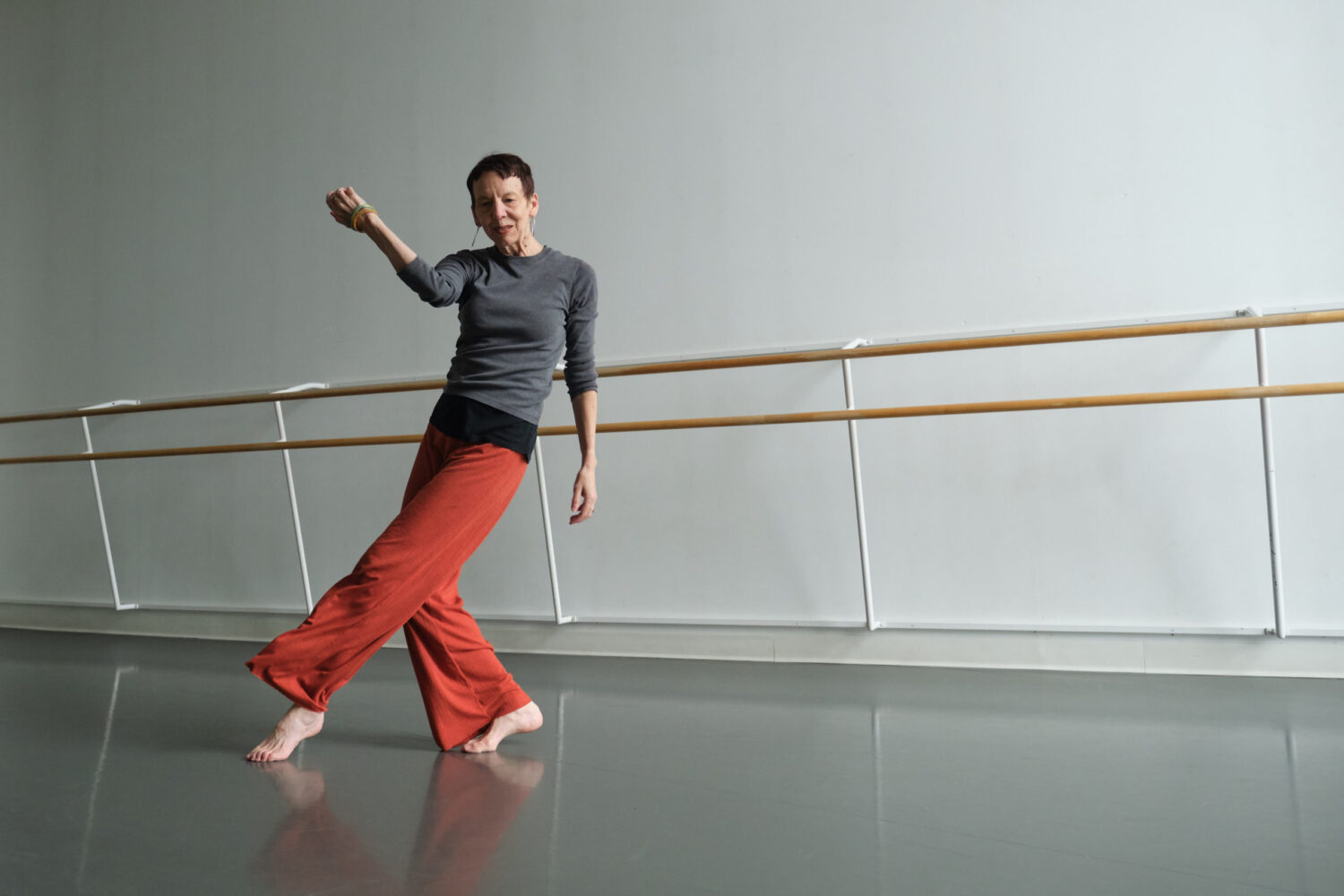 One dancer in a studio, wearing orange loose-fitting pants