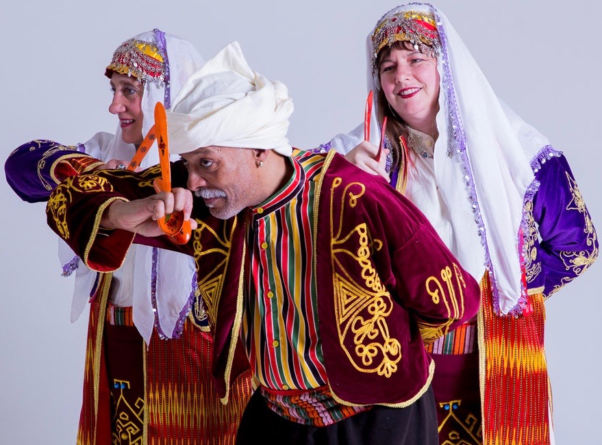 Three dancers in traditional Anatolian garb with ornamental Turkish spoons