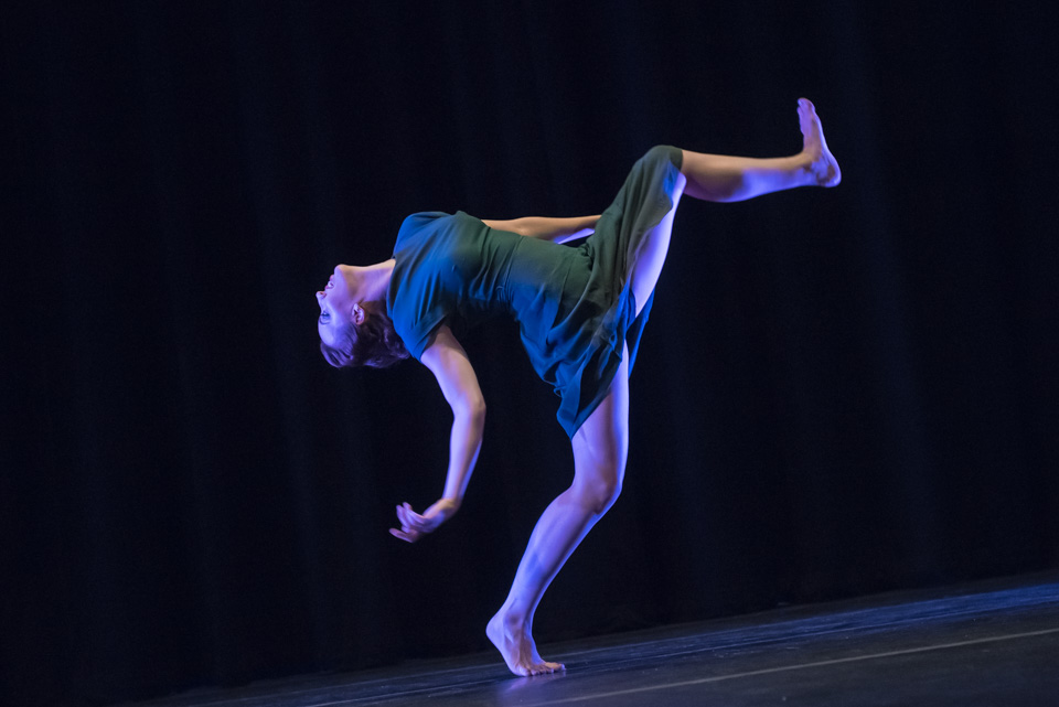 One dancer leaning back with one leg lifted toward a giant step