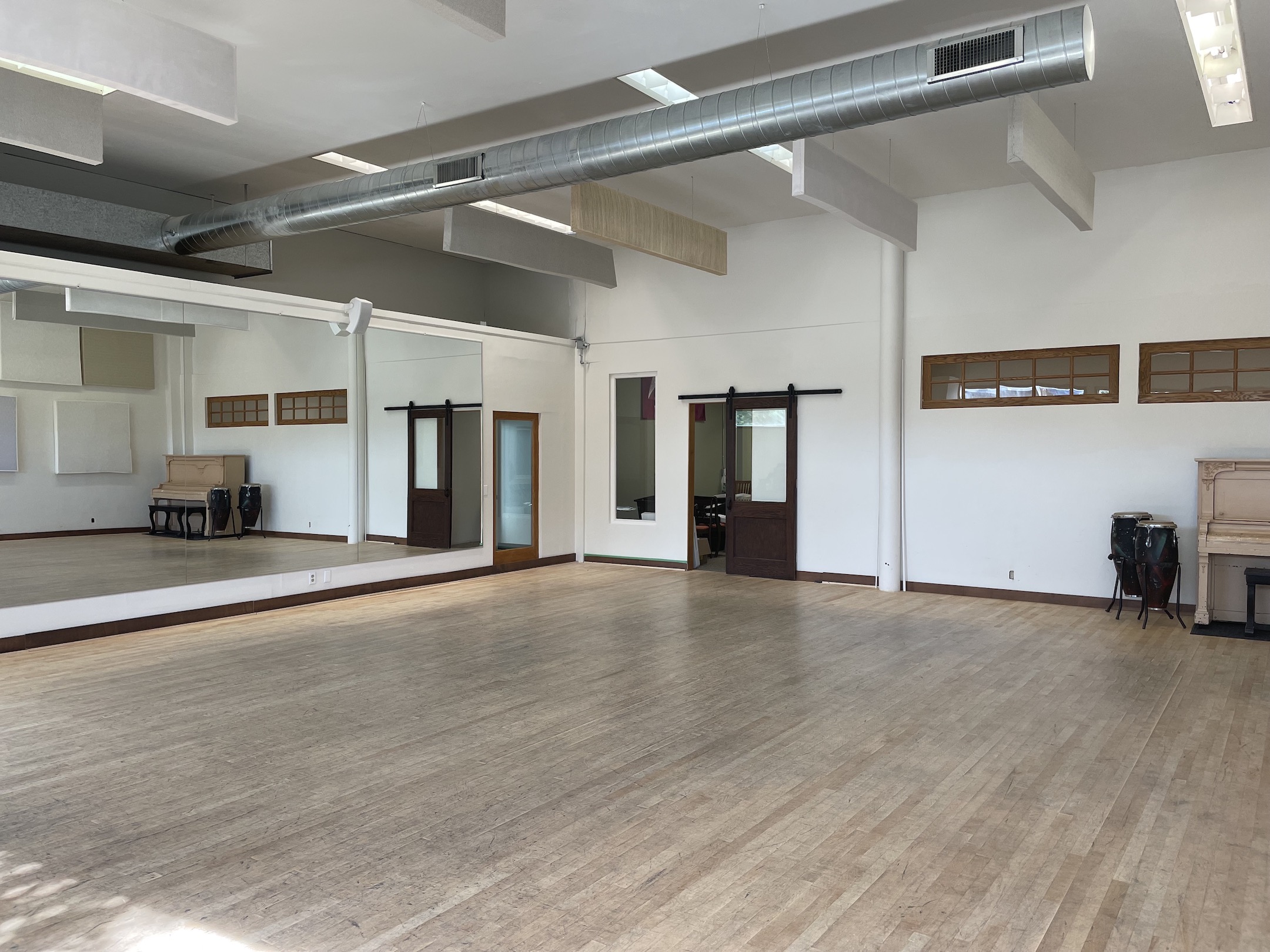 An image of Studio 1 at Keane Sense of Rhythm. There are white walls, mirrors, and a maple floor