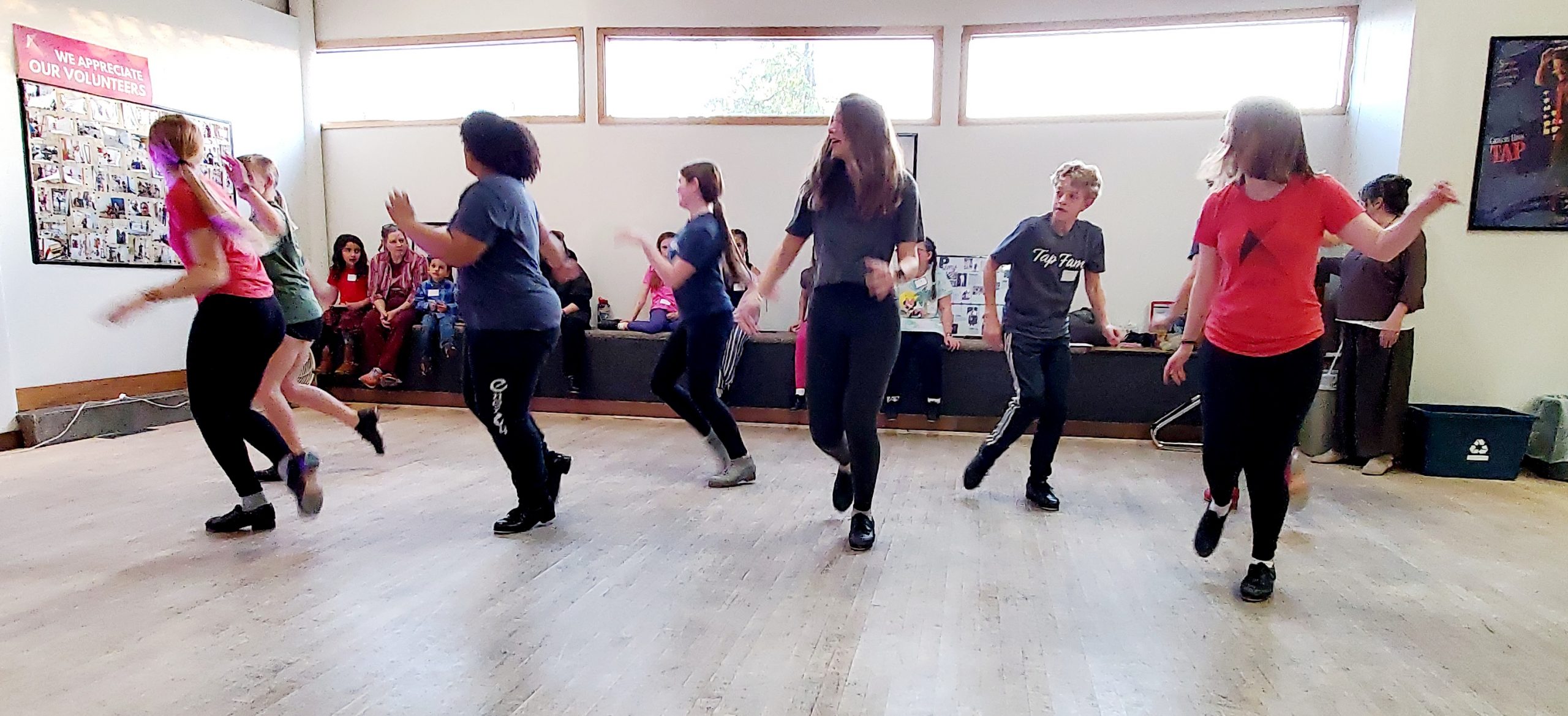 A classroom of youth practice tap dance