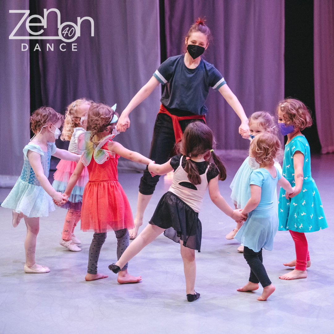 A group of young dancers form a circle with their teacher